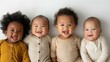 © Glittering Humanity - A set of four smiling infants dressed in varying brightly colored outfits, sitting together on a sleek white background, capturing a scene full of happiness and purity.