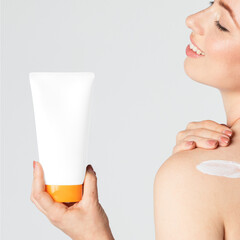 Sticker - Cheerful woman holding a cream tube container mockup