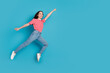 © deagreez - Full length photo of shiny attractive lady dressed red t-shirt jumping high hurrying empty space isolated blue color background