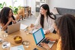 © Studio Marmellata - Women having a discussion around a table with laptops in an office setting Focus is on their conversation and interaction