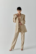 © LIGHTFIELD STUDIOS - A woman in a beige suit poses against a white backdrop.
