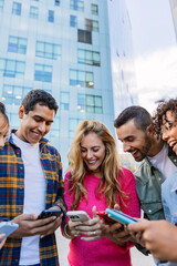 Vertical shot of young group of student friends using mobile phone at college campus. Technology lifestyle concept.