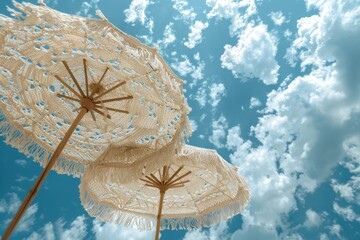 Two white umbrellas are open in the sky, with a blue sky behind them