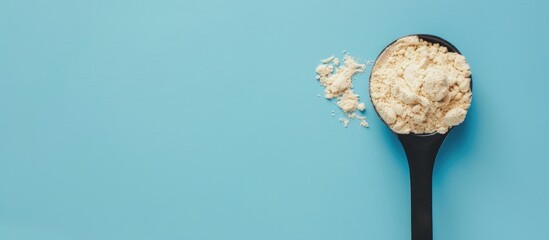 Sticker - Measuring spoon holds whey protein powder; set against blue backdrop with available copy space image.