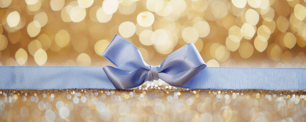 Wall Mural - A soft periwinkle blue ribbon bow on a gold glitter background. The gentle color and shimmering backdrop create a delicate and elegant feel.