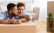 © Prostock-studio - Moving. African American Couple Hugging Sitting On Floor Among Unpacked Boxes Smiling At Camera After Relocation In New Apartment
