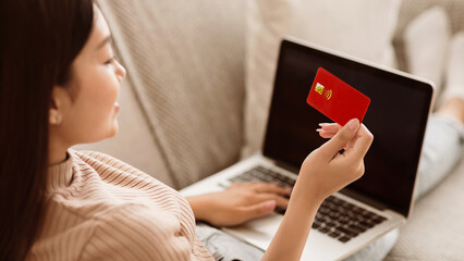 Poster - E-Commerce Concept. Girl With Cedit Card And Laptop With Blank Screen