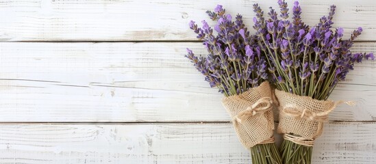 Poster - A dried lavender bouquet, gift-wrapped in textured green burlap, set on a white wooden background. Ideal for aromatherapy, organic home decor, spa, and Mother's Day, with room for copy space image.