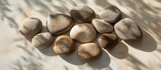 Poster - Granite stones arranged on a beige surface with shadows, suitable for copy space image.