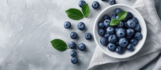 Poster - Wide photo of a white bowl filled with fresh blueberries on a linen napkin with spacious copy space image.