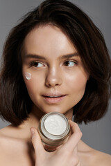 Wall Mural - A woman applies cream to her face.