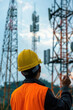 © Neha - Engineer holding safety helmet with telecommunication tower pillars