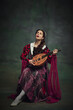 © master1305 - Portrait of beautiful young woman playing with a lute against vintage green background. Classical music concerts and opera events. Concept of history, comparison of eras, remake