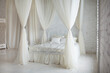 © sergiophoto - Serene minimalist white bedroom with canopy curtains and natural light is a peaceful experience