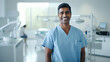 © Neha - happy young indian male dentist standing in hospital