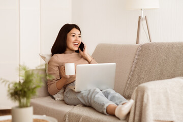 Wall Mural - Girl Talking on Phone, Enjoying Morning Coffee and Using Laptop at Home, Copy Space