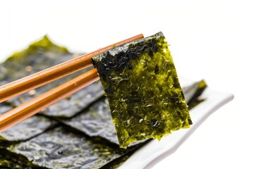 Wall Mural - Crispy nori seaweed isolated with chopsticks on white background Dry seaweed sheets