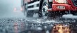 © Thanapipat - Blurred fire truck in the rain with water splashing on the road, capturing the urgency and motion of emergency services.