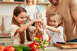© Valerii Apetroaiei - Happy Family Engaged in Preparing a Healthy Salad Together in Their Home Kitchen