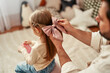 © Valerii Apetroaiei - A father ties a bow in his daughters hair, showing a strong bond and affectionate relationship