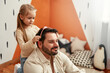 © Valerii Apetroaiei - Father and Daughter having fun, child adding hair accessories to her dad in a playroom