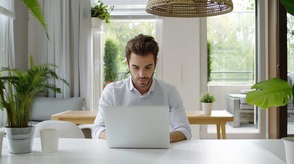 Poster - A man sits at a table in his home office, working on a laptop computer.