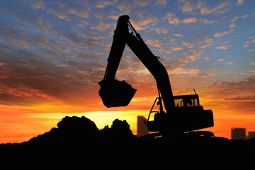 Wall Mural - Crawler excavators silhouette are digging the soil in the construction site. on  sunset background