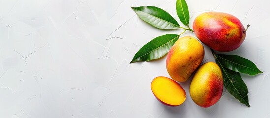 Poster - Top-down view of a mango fruit and sliced half with copy space image on a white background, perfect for adding text.