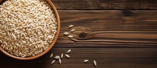 Poster - Pearl barley grain set against a rustic wooden backdrop with copy space image.