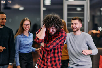 Wall Mural - A group of young business people have fun playing interesting games while taking a break from work in a modern office. Selective focus 