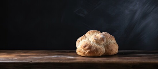 Poster - Dough lump resting on a wooden table with a dark backdrop, showing ample copy space image.