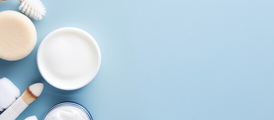 Poster - Skin care concept featuring beauty items like hyaluronic acid, a face massage brush, and face cream, displayed on a blue backdrop in a flat lay image with copy space.