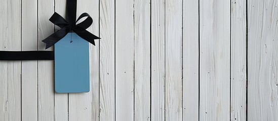 Poster - White wooden background with an empty blue label and black ribbon for your text or advertisement in a vintage, retro, or rustic style, including copy space image.