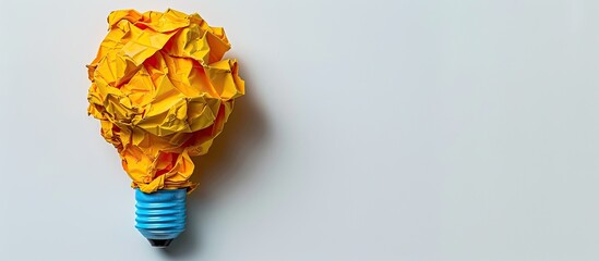 Aufkleber - Crumpled colored paper shaped like a yellow light bulb on a white background with a copy space image.