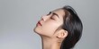 © MD Media - Beautiful Asian woman with perfect skin, portrait of beautiful young model posing on gray background with closed eyes and open mouth in profile, skin care concept, close up side view