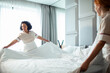 © Marko Geber - Hotel maids changing bed linens in a bright room