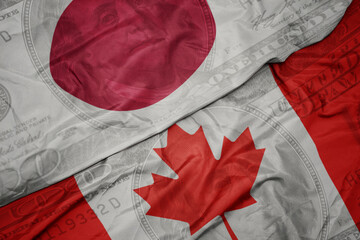 Poster - waving colorful flag of japan and national flag of canada on the dollar money background. finance concept.