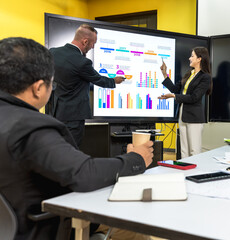 Man and woman presenting business strategy chart on screen in conference meeting 