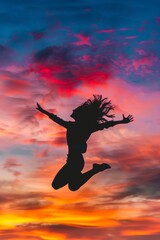 Canvas Print - Bold silhouette of a girl jumping joyfully against a colorful sunset.