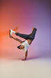 © LIGHTFIELD STUDIOS - A young African American man dances in a studio with a colorful gradient background.