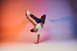 © LIGHTFIELD STUDIOS - A young African American man dances on a gradient background, showcasing his impressive skills.