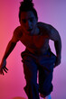 © LIGHTFIELD STUDIOS - An African American man dances in front of a pink and blue gradient background.