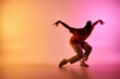 © LIGHTFIELD STUDIOS - A young African American man dances on a colorful gradient background, showcasing his skill and passion for movement.