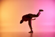 © LIGHTFIELD STUDIOS - A young African American male dancer performs a dynamic pose against a colorful gradient background.