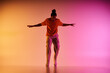 © LIGHTFIELD STUDIOS - A young African American man dances energetically against a vibrant gradient background, embodying contemporary dance.