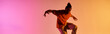 © LIGHTFIELD STUDIOS - A young African American man dances with vibrant energy against a colorful gradient background.
