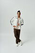 © LIGHTFIELD STUDIOS - A young African American man, wearing a white tracksuit, poses against a grey background.