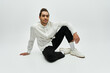 © LIGHTFIELD STUDIOS - A stylish African American male model poses in a white shirt and black pants on a grey background.