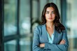 © id512 - confident young businesswoman in blue suit with arms crossed in modern office setting, professional leader portrait