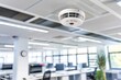 © Ben - Modern smoke detector installed in an office ceiling, highlighting safety and fire prevention in a professional indoor setting